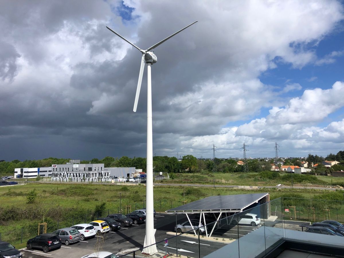 Installation éolienne de 25 kW sur un mât autoportant basculant et carport solaire photovoltaïque 